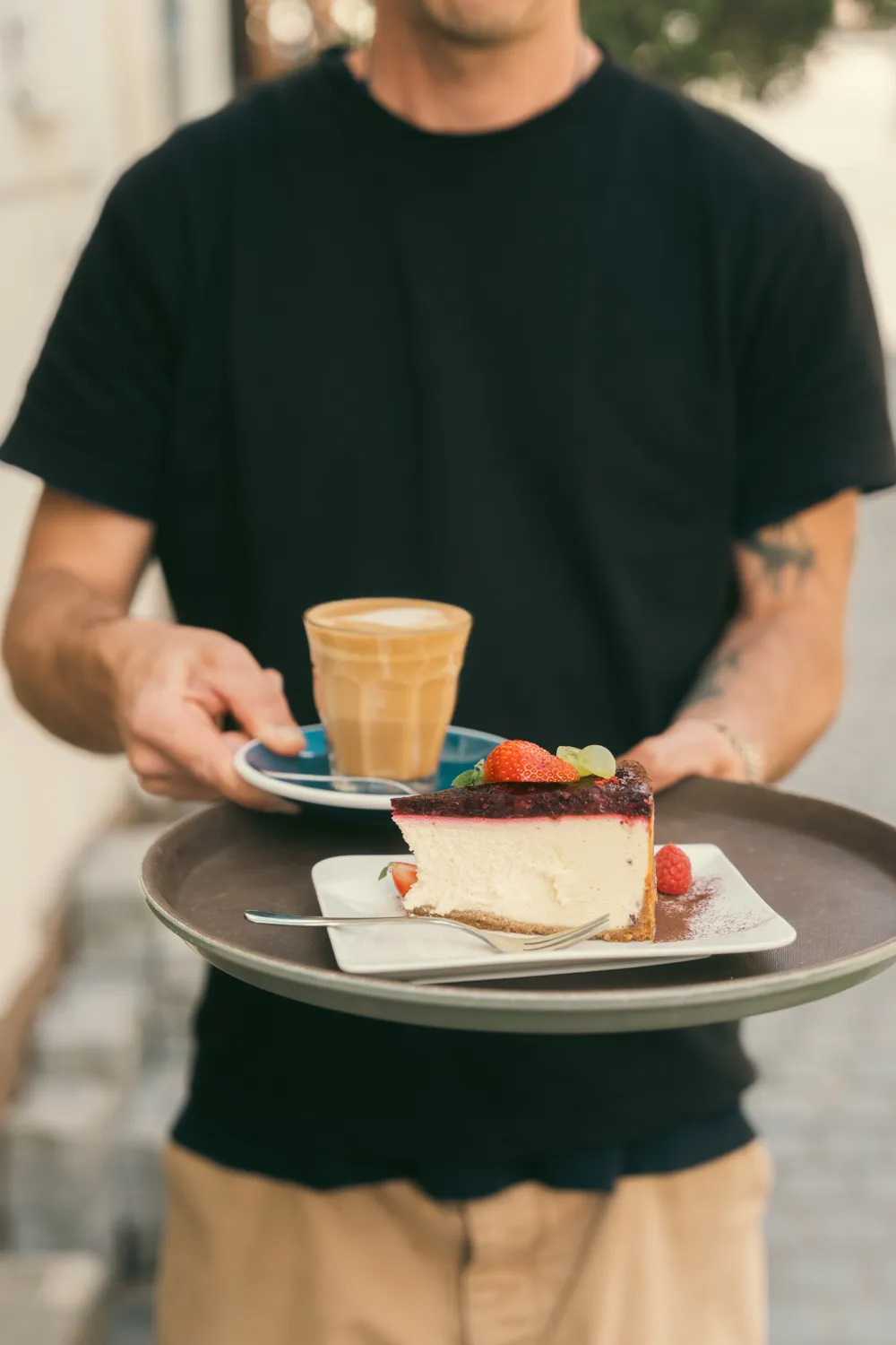 Felszolgáló hozza a sajttortát és a lattét a Manooka Kávézóban, Eger
