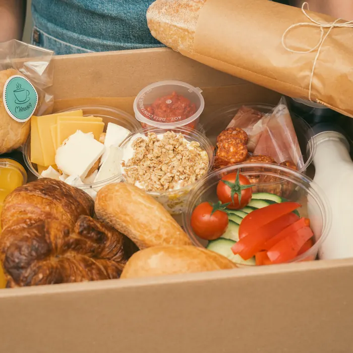 Kézben tartott box croissant-nal, bagettel és üdítővel