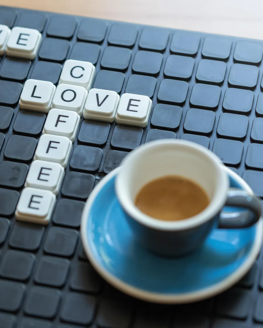 Espresso türkiz csészében és „We love coffee” betűkirakó a Manooka asztalán