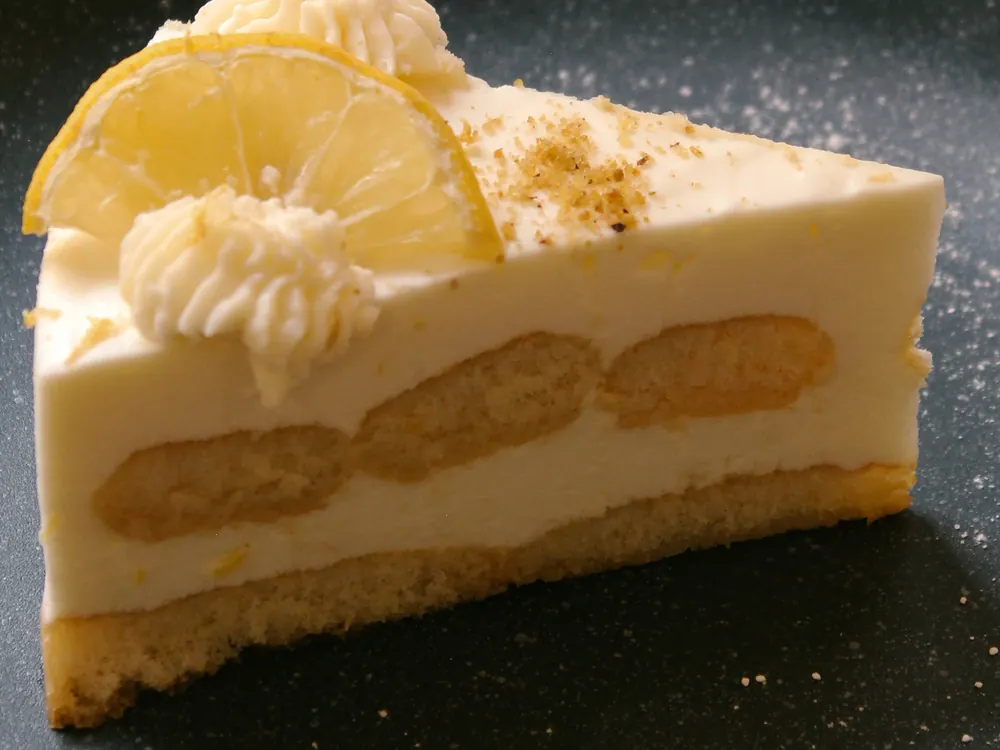 Krémes tortaszelet sötét tányéron